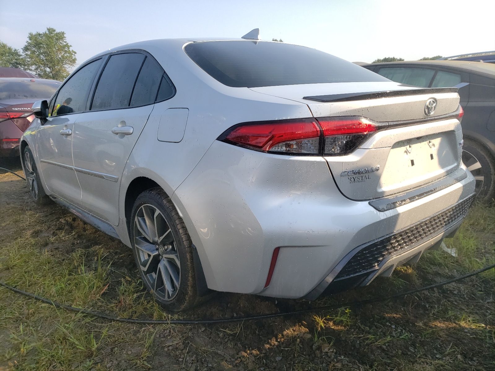 Rear three-quarter view of a silver Toyota Corolla sedan at an outdoor vehicle auction