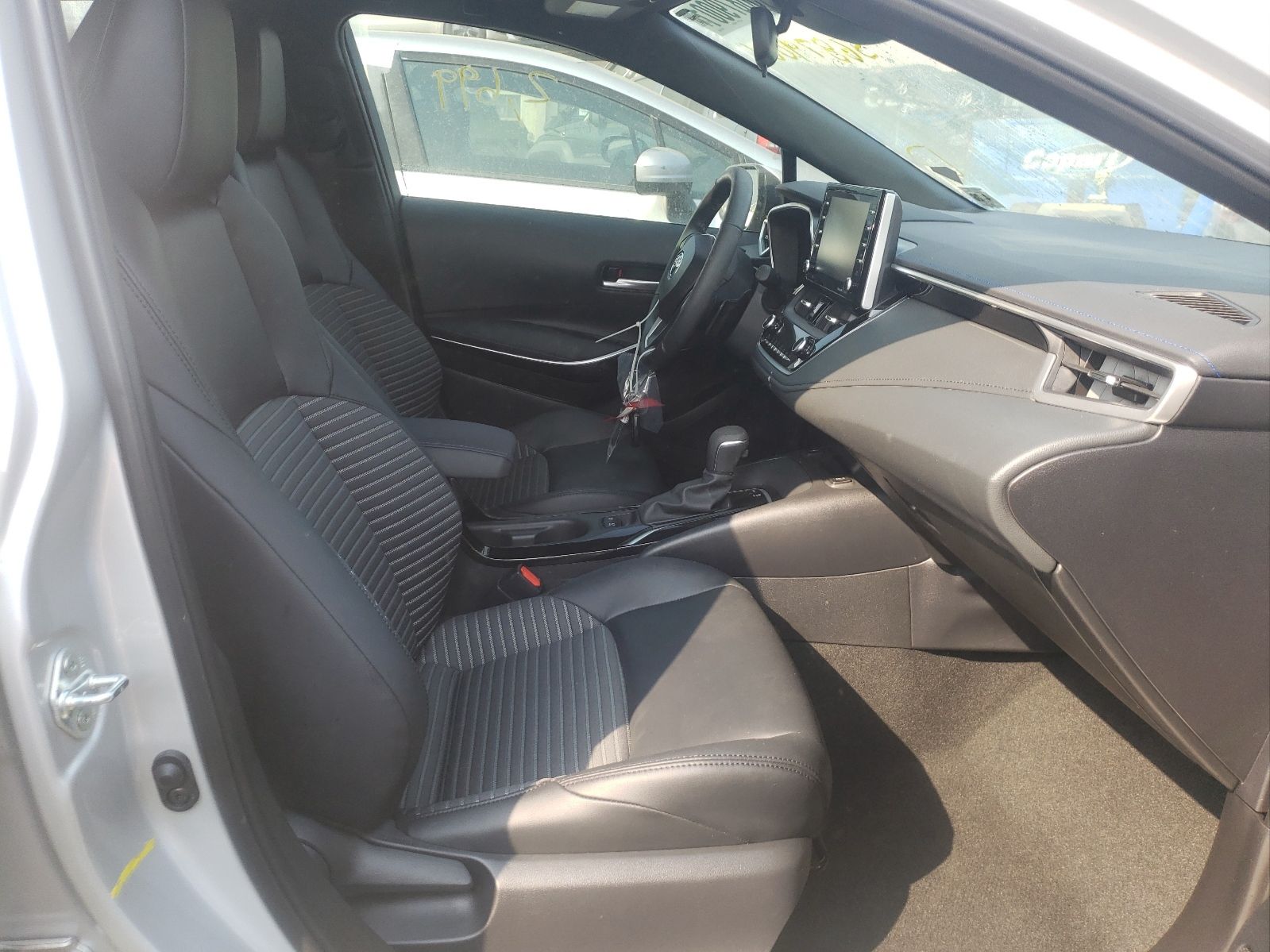 Interior of a Toyota Corolla showing front seats, center console, and touchscreen dashboard